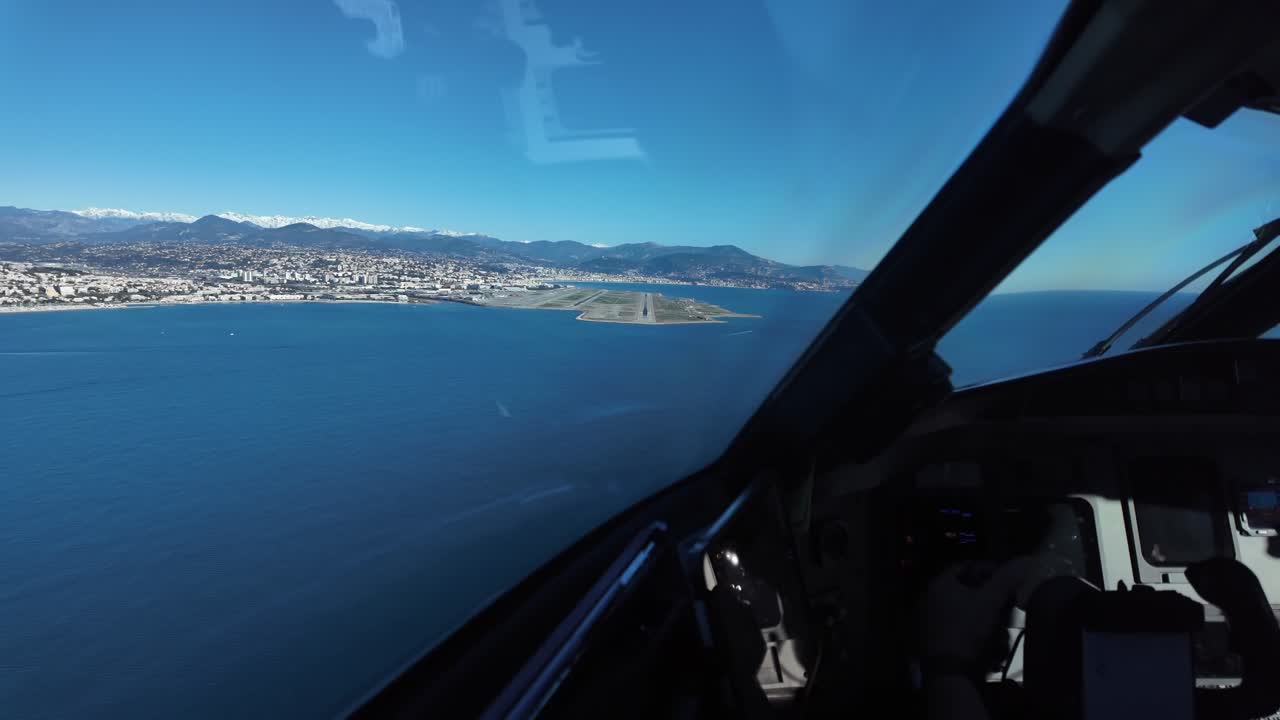 POV kokpit waktu nyata selama pendekatan terakhir ke bandara Nize, terbang di atas Laut Mediterania, dengan landasan pacu bandara 04R di depan, dan puncak bersalju Pegunungan Alpen di belakang. Tampilan imersif