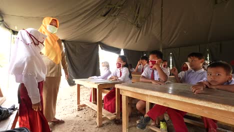 students and a teacher in a temporary tent classroom