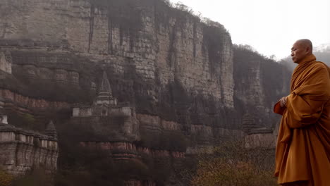 monk walking near cliffside temple