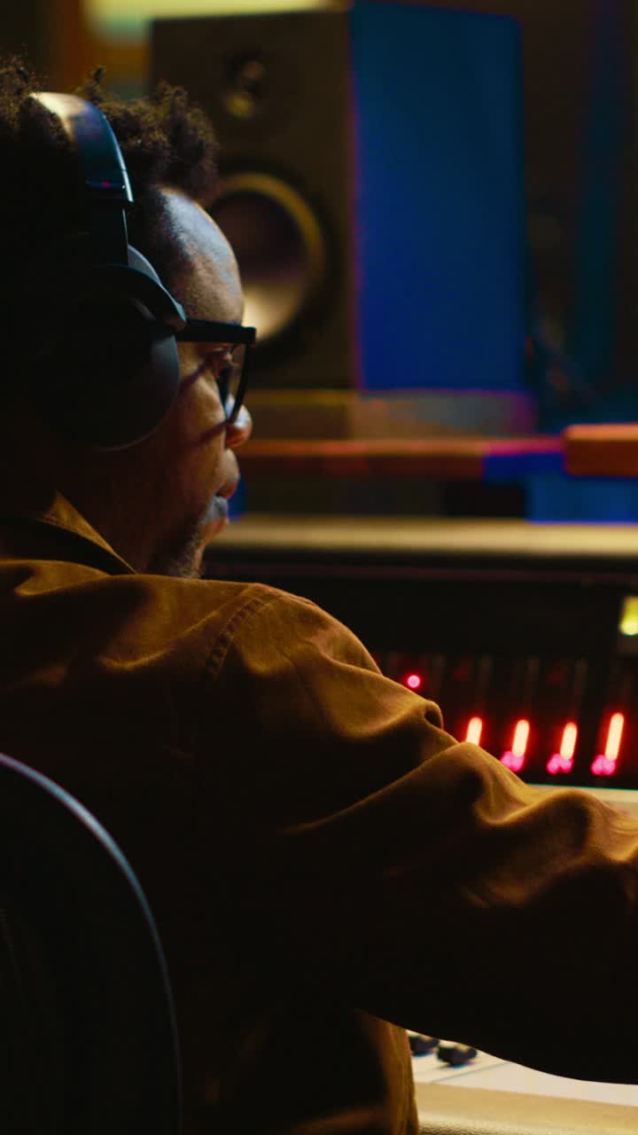 Professional Audio Engineer Mixing Music in a Dark Studio