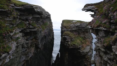 tilt-down push-forward drone shot of ocean cliffs