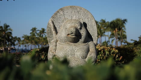 Bear-Statue-Sits-in-the-Middle-of-Green-Bushes-Blowing-in-Wind