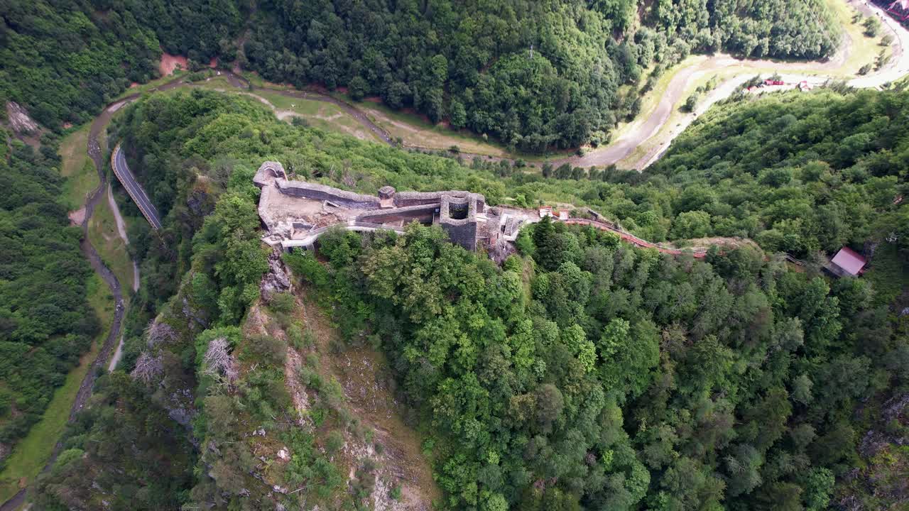 majestuosa vista aérea de la ciudadela de poenari, ruinas históricas de la fortaleza en un pico de montaña, rodeado de denso bosque
