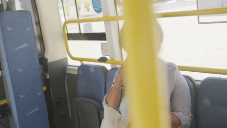 happy plus size biracial woman talking on smartphone in bus