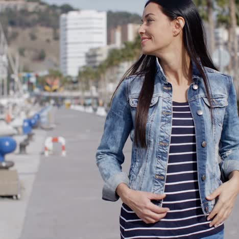 Casual-woman-enjoying-a-walk-through-a-marina