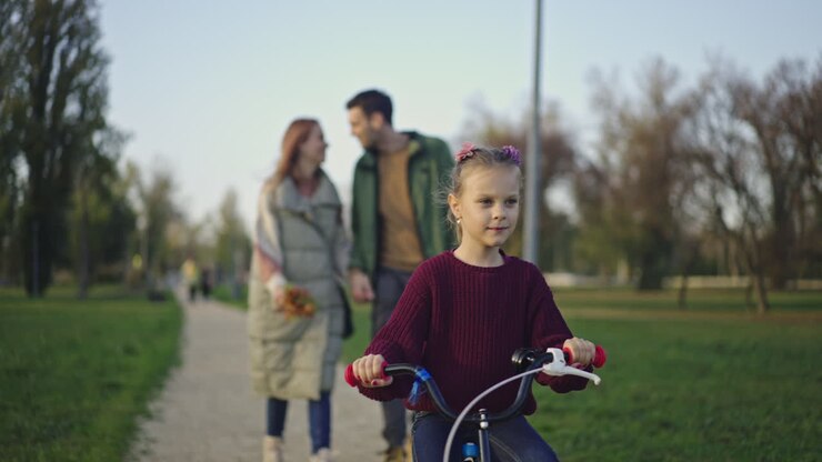 Family in the park with child riding a bicycle