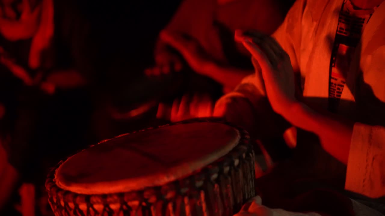 un grupo de personas tocando tambores en el desierto del sahara, marruecos, áfrica