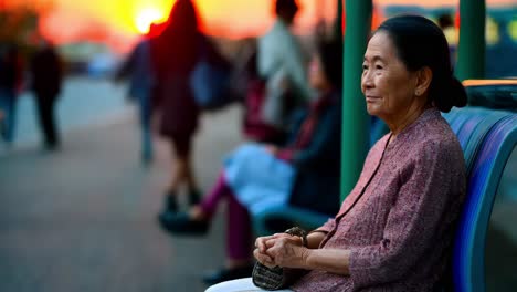 elderly woman waiting at sunset