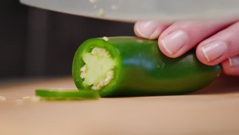 Mano-Del-Chef-Cortando-Chile-Jalapeño-Verde-Con-Un-Cuchillo-Afilado-En-La-Tabla-De-Cortar-En-Un-Montón-De-Rebanadas-En-Cámara-Lenta