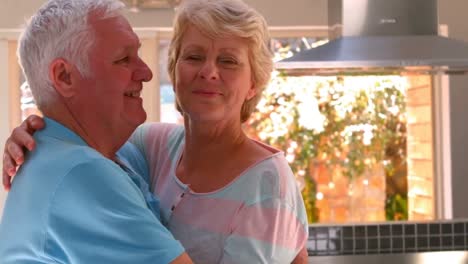 Senior-couple-embracing-in-kitchen