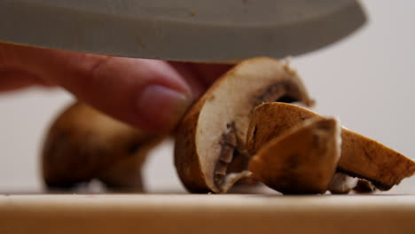 chef slices small mushrooms