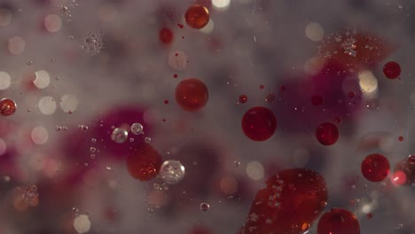 abstractas burbujas claras y salpicaduras rojas de sangre movimiento bokeh textura líquida fondo