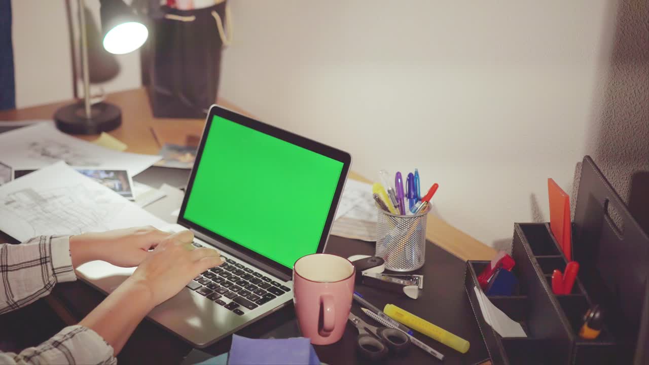Person Working on Laptop at a Home Office Desk at Night