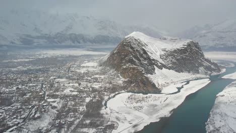 Drone-shot-of-snow-covered-landscape-of-hills-and-rivers-in-Skardu-city,-Pakistan