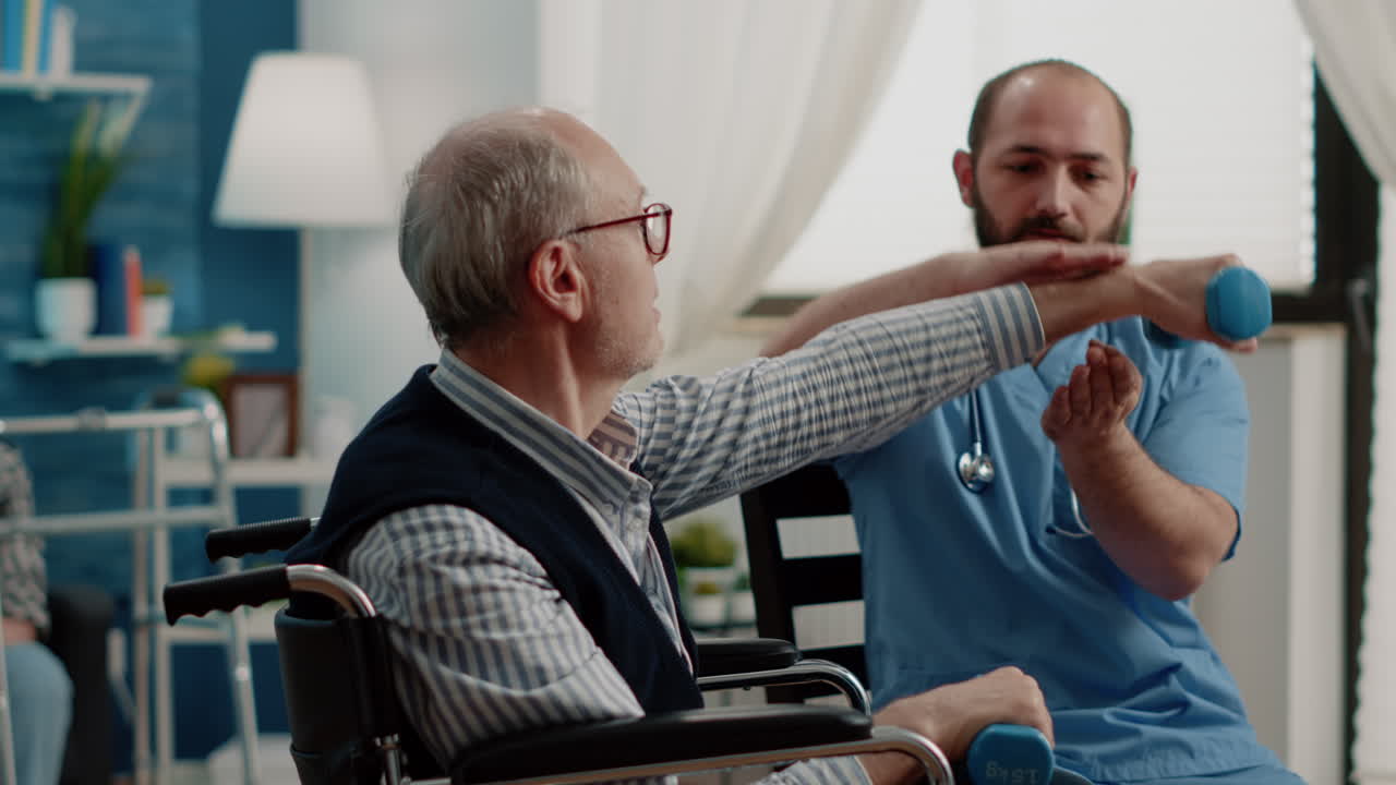 Medical assistant helping disabled patient with dumbbells