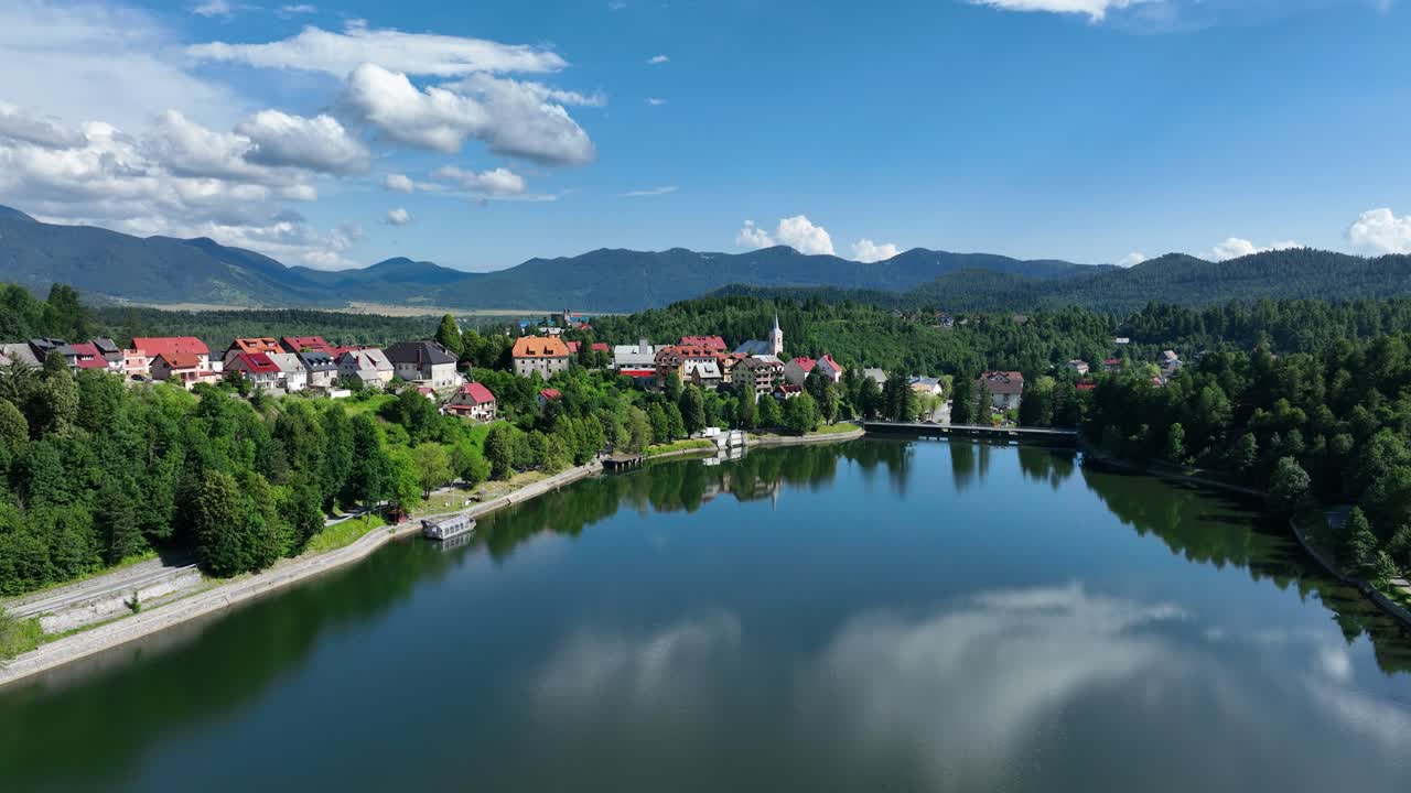 Vista aerea di un pittoresco villaggio di montagna adagiato vicino a un lago sereno
