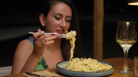 smile on the face of a woman eating spaghetti for dinner at the restaurant