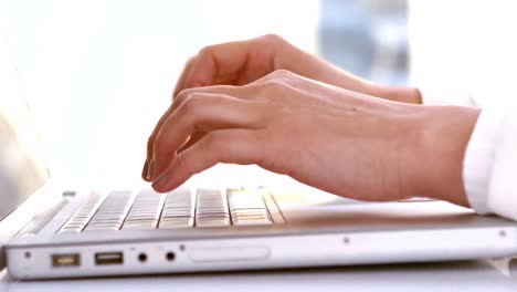 mujer de negocios escribiendo en su computadora portátil