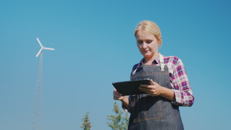 a young female farmer uses a tablet in a field technology in agriculture