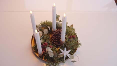 turning on electric candles on christmas advent wreath