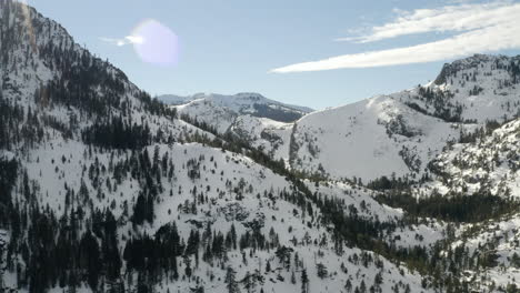 aerial push in to the snow covered mountains surrounding emerald bay in lake tahoe california