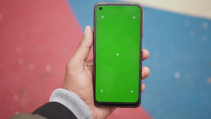 Persona che tiene un telefono con schermo verde