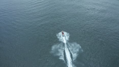 aerial, jet ski sailing fast on lake during the day