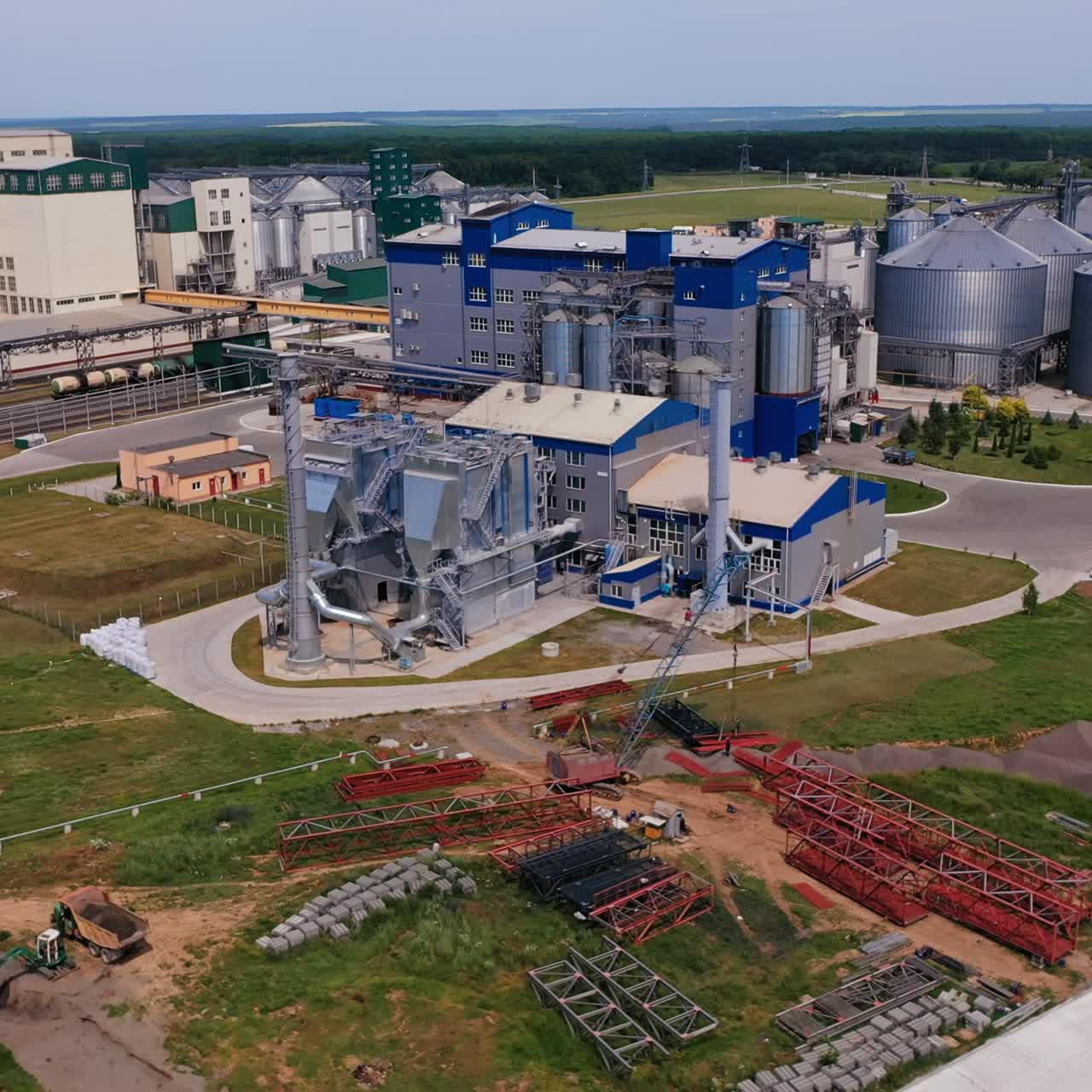 Present day granary plant with newly built premises and ones under construction. Abundant industrial zone in the fields. Nature background