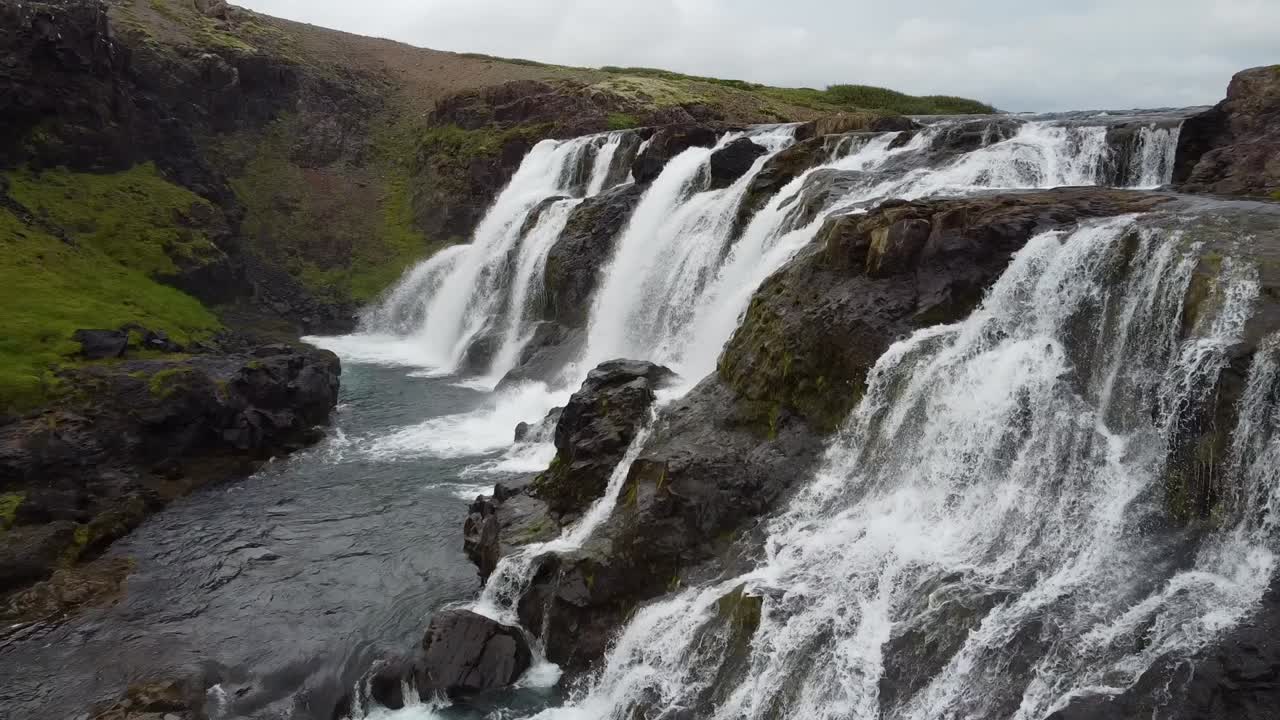 cascada ancha que fluye por las rocas en la naturaleza de islandia, paisaje aéreo