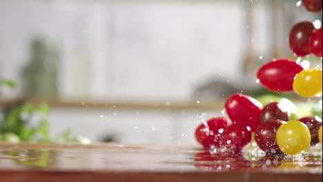 slow motion of mix of cherry tomatos falling on wet wooden board in a kitchen