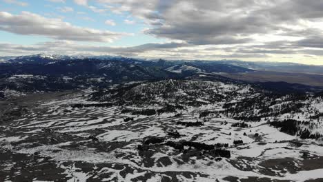drone shot of the mountains and the valley bellow, dotted with snow
