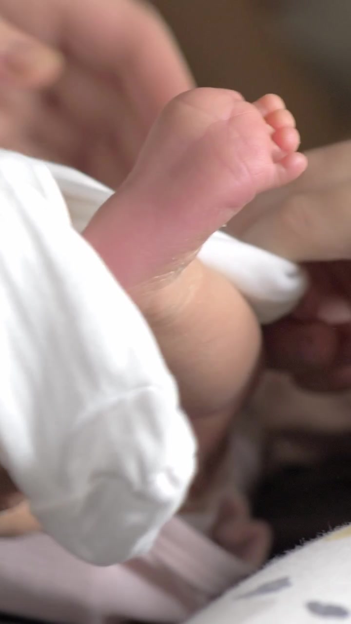 Bambino che aiuta la nonna a vestire il neonato