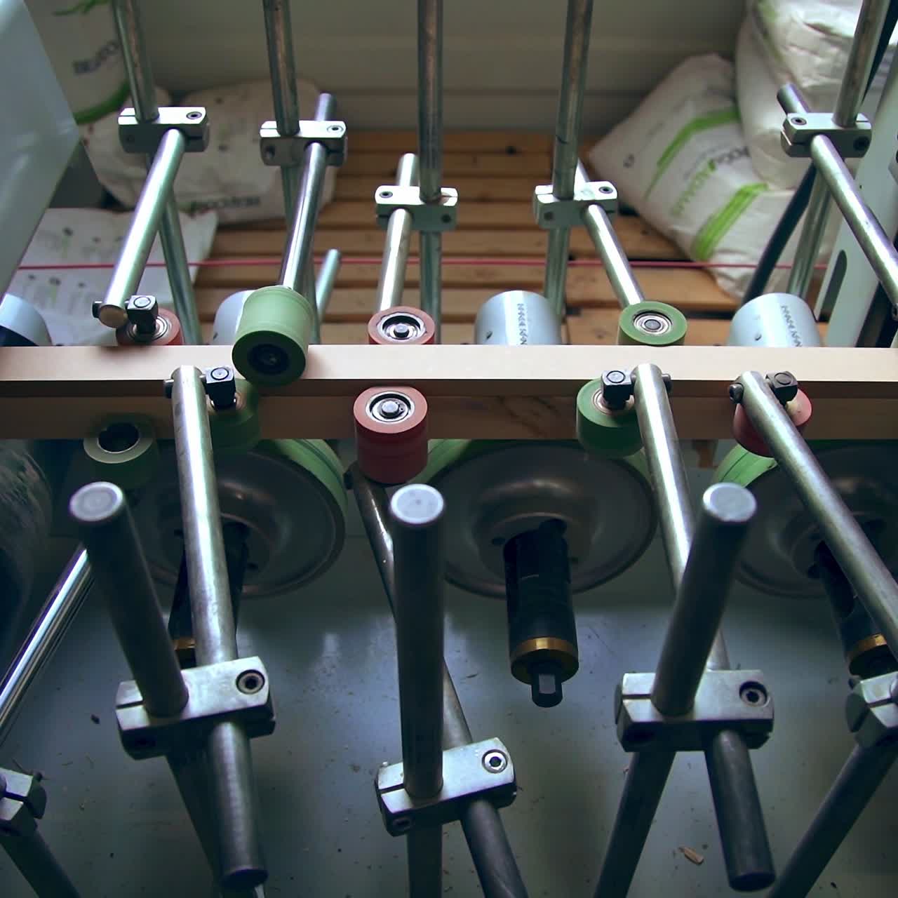 Conveyor line with multiple rollers. Timber bar is moved along the spinning shafts for following processing