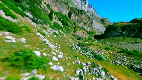 fpv drone diving the mountains, close up the rocks and green trees