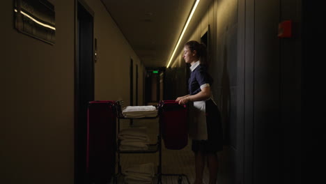 hotel maid cleaning a hallway at night