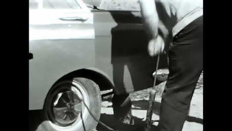 man standing next to car in old black and white video from the soviet union archive. circa ussr 1970: an intriguing black and white video capturing a man standing next to a classic car, preserved in the soviet unions archive.