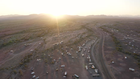 retroceso aéreo sobre vehículos recreativos estacionados en un desierto de arizona al atardecer