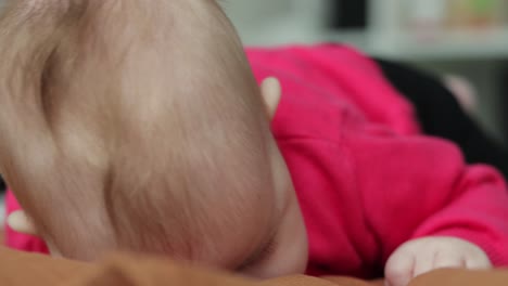 close up of young baby girl prone on stomach to help muscle development