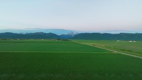 Road-Through-Lush-Green-Fields-In-Driggs,-Teton-County-In-Idaho,-USA