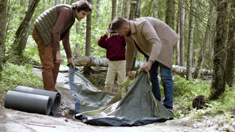 Junge-Familie,-Die-Zelt-Nahe-Dem-Fluss-Aufstellt