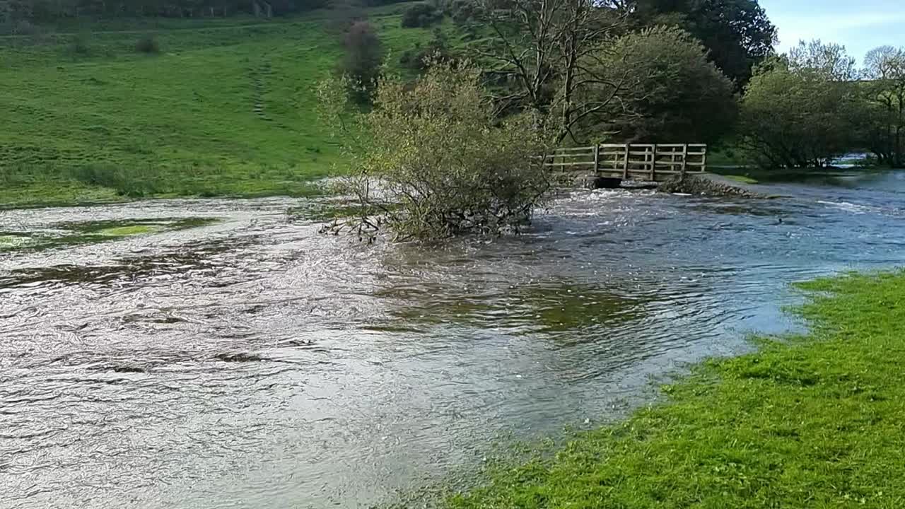 천천히 움직이는 포화 된 홍수 시골 하천은 폭풍의 날씨 자연 재해 후 침수 된 나무로 은행을 터뜨렸습니다.