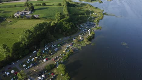 sunny family camping: aerial video of a full lakeside campsite during a summer getaway