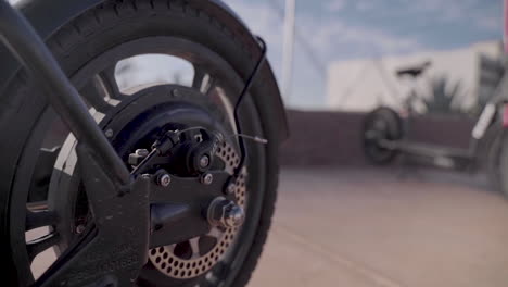 rental scooter tire with disk brake on a street in a busy urban metropolitan