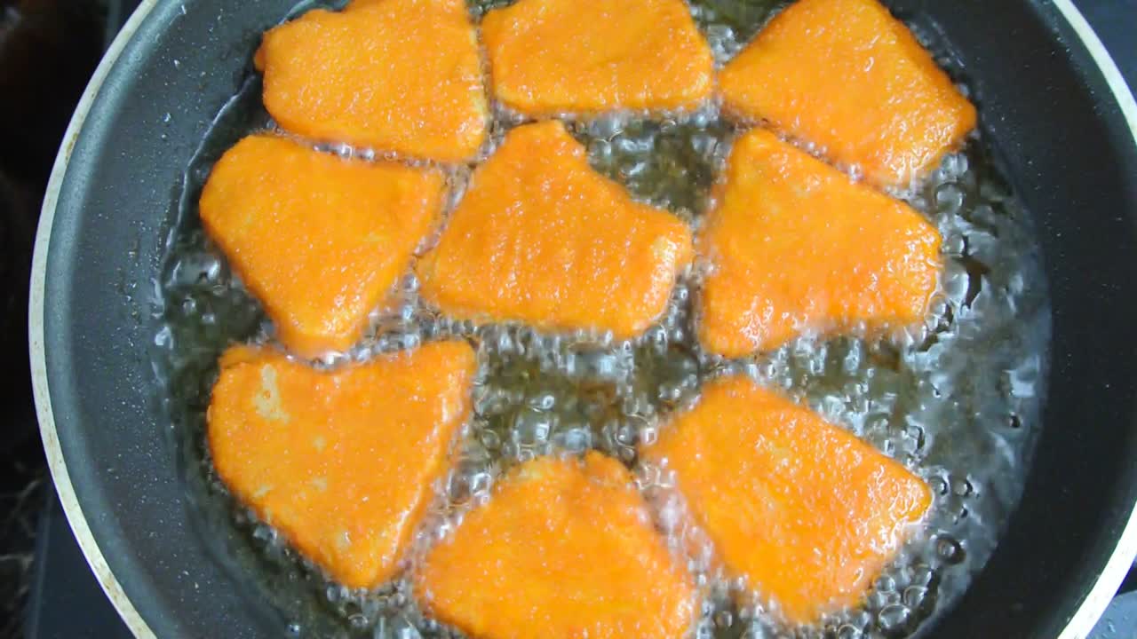 Chicken nuggets are fried using cooking oil in a pan