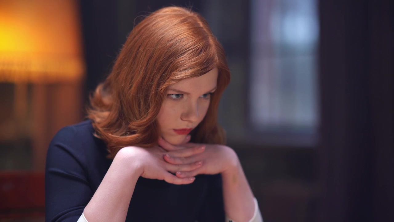 Pensive Redhead Woman Thinking Deeply with Hands Clasped