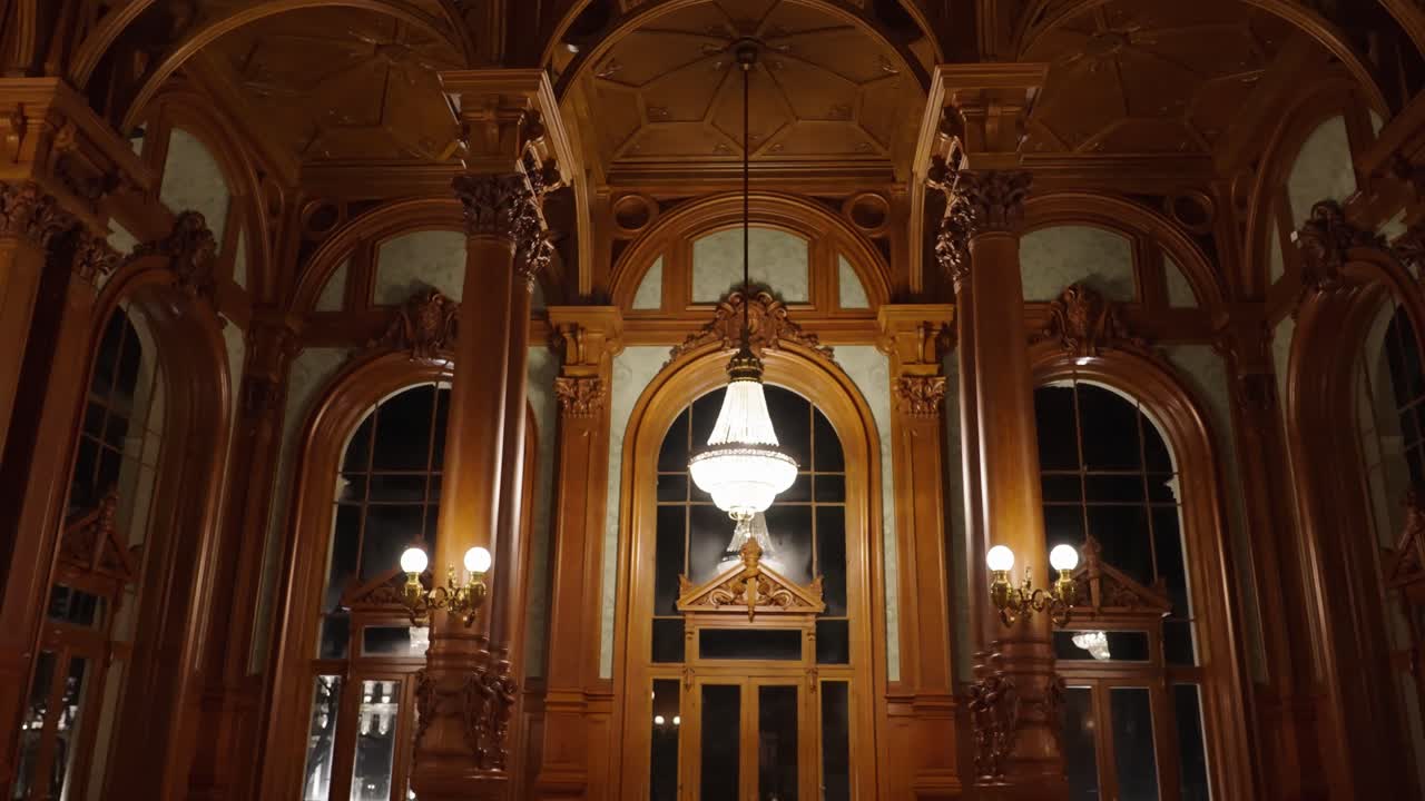 천장과 아치 창문에서 매달린 들리어가 있는 고급스러운 목조 방으로 들어가세요.