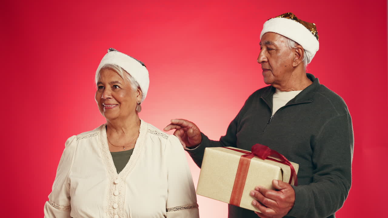 Elderly couple exchanging Christmas gifts