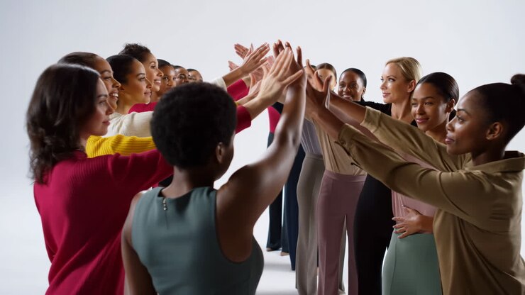 Grupo diverso de mulheres celebrando o sucesso com um high five