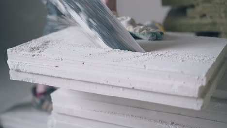 worker in gloves prepares and saws gypsum plasterboard