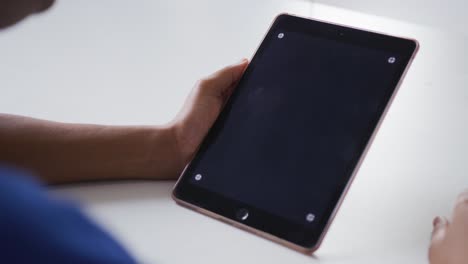 mujer de negocios afroamericana sentada en un escritorio haciendo una videollamada usando una tableta con espacio para copiar